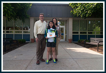 Ella holding her award with her parents Mike and Jill